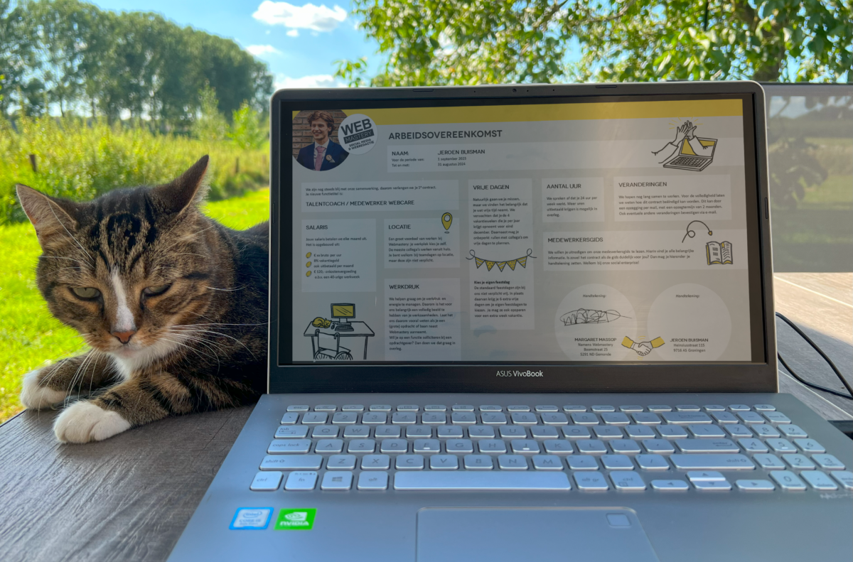 Laptop met de arbeidsoverenkomst van Jeroen, met een kat ernaast.